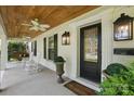 Inviting covered porch features rocking chairs, swing, and stylish lighting fixtures at 5400 Glenham Dr, Charlotte, NC 28210
