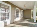 Covered front porch featuring stone flooring, beadboard ceiling, and abundant natural light through multiple windows at 631 Dogwood Rd, Statesville, NC 28677