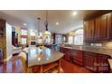Gourmet kitchen featuring custom cabinetry, granite countertops, stainless steel appliances, and a center island with seating at 708 Ridgelake Dr, Weddington, NC 28104