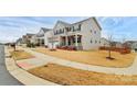 View of neighborhood street showing home with attractive landscaping, front porch, and two car garage at 7266 Waterwheel Sw St, Concord, NC 28025