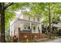 Attractive two-story home featuring a spacious front porch with white railings and a brick foundation at 734 E 10Th St, Charlotte, NC 28202
