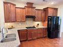 Beautiful kitchen featuring granite countertops, tile backsplash, and dark wood cabinetry at 7581 Short Putt Ct, Charlotte, NC 28215