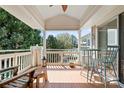 Cozy outdoor balcony featuring a wooden deck, white railing, and comfortable seating arrangement with lake views at 7844 Village Harbor Dr, Cornelius, NC 28031