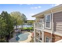 Exterior view of a condo building overlooking a pool, lake view, and private balcony with a covered porch at 7844 Village Harbor Dr, Cornelius, NC 28031