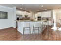Well-lit kitchen with stainless appliances, granite counters, and bar stool seating at 7854 Springs Village Ln, Charlotte, NC 28226