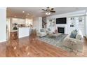 Bright living room featuring hardwood floors, a cozy fireplace, and elegant built-in shelving with an open layout at 7854 Springs Village Ln, Charlotte, NC 28226
