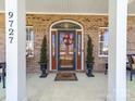 Inviting front porch with brick facade, featuring a welcoming entrance and decorative accents at 9727 Glenburn Ln, Charlotte, NC 28278