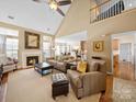 Bright living room features a fireplace, vaulted ceilings, and open layout to the kitchen and dining area at 9727 Glenburn Ln, Charlotte, NC 28278