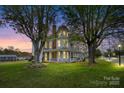 Stately two-story home with a rounded tower, lush lawn, and inviting wrap-around porch at 101 E Main St, Cleveland, NC 27013
