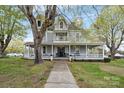 Inviting two-story home with a charming wrap-around porch, mature trees, and meticulous landscaping at 101 E Main St, Cleveland, NC 27013