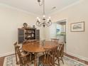 Elegant dining room with a wooden table, ornate chandelier, and a glimpse into the adjacent kitchen at 1018 Davant Ln, Charlotte, NC 28209