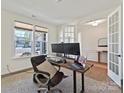 Bright office space featuring large windows, a wooden desk, and a comfortable ergonomic chair at 104 Hemlock Cove Ct, Mooresville, NC 28117