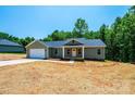 New construction, single-story home featuring a front porch and attached garage, set on a partially wooded lot at 1127 Mckay Rd, Newton, NC 28658