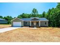 Single-story home with an attached garage, a welcoming front porch and large windows, in new neighborhood at 1127 Mckay Rd, Newton, NC 28658
