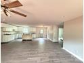 Open-concept living area featuring modern ceiling fan, wood floors, and access to kitchen and exterior at 1127 Mckay Rd, Newton, NC 28658