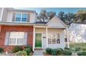 Attractive townhome with a brick accent, bright green door, and manicured bushes at 11630 Retriever Way, Charlotte, NC 28269