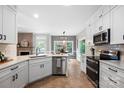 Modern kitchen with white cabinetry, stainless steel appliances, and adjacent breakfast nook and living area at 1214 Foxfield Rd, Waxhaw, NC 28173