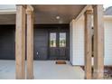 Inviting covered entryway featuring sturdy wooden pillars and stylish double doors, creating a warm welcome to the home at 1429 Coppergate Dr, Salisbury, NC 28147
