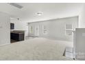 Open-concept living room with neutral carpet, a fireplace, and access to a kitchen bar, perfect for entertaining at 14328 Evening Flight Ln, Charlotte, NC 28262