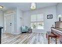 Bright living room featuring a light-filled window, wood floors, and comfortable seating area at 14911 Barnsbury Dr, Huntersville, NC 28078