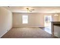 Carpeted living room with a sliding glass door to the backyard and an adjacent kitchen at 2035 Talbert Ct, Charlotte, NC 28214