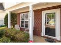 A welcoming porch area featuring brick columns, ample natural light, and seating, perfect for enjoying the outdoors at 2319 Arbor Vista Dr, Charlotte, NC 28262