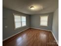 Bright bedroom features two windows, neutral walls, and hardwood flooring at 3316 Queens Ln # 10, Gastonia, NC 28052