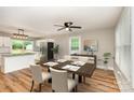 Inviting dining area featuring hardwood floors, modern lighting, and views of a bright and airy kitchen at 5316 Teakwood Dr, Kannapolis, NC 28083
