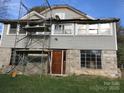 Two-story home undergoing renovation with stone foundation, scaffolding, and updated windows at 613 E 5Th St, Spencer, NC 29159