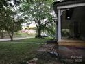 Vintage home featuring detailed porch columns, green lawn, and a glimpse of the surrounding neighborhood at 613 E 5Th St, Spencer, NC 29159
