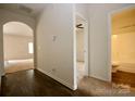 Bright hallway with wood-look flooring, leading to carpeted living areas and a bathroom at 8606 Highgate Dr, Charlotte, NC 28215