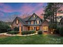 Charming two-story brick home with lush landscaping and inviting entrance at dusk at 8915 Linden Grove Ct, Sherrills Ford, NC 28673