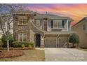 Charming two-story home featuring a stone and siding exterior, two-car garage, and well-maintained landscaping at 9422 Ridgeforest Dr, Charlotte, NC 28277