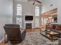 Cozy living room with vaulted ceiling, fireplace, hardwood floors and large windows for ample natural light at 1009 Summer Creste Dr, Indian Trail, NC 28079