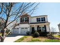 Attractive home featuring a two-car garage, covered porch, and mature landscaping at 1090 River Haven Sw Ave # 61, Concord, NC 28025
