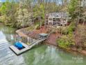 Lakefront home featuring a private dock and shoreline, surrounded by mature trees at 176 Sunset Bay Dr, Troutman, NC 28166