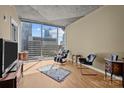 Bright living room featuring a large window with city views, hardwood floors, and stylish furniture at 210 N Church St # 2305, Charlotte, NC 28202