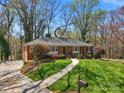 Attractive brick home with a green lawn, landscaping, and a concrete walkway leading to the front door at 3524 Johnny Cake Ln, Charlotte, NC 28226