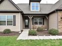 Inviting front porch with rocking chairs, stylish front door, and well-manicured landscaping at 4425 Marlay Park, Indian Trail, NC 28079