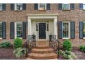 Close up of stately front entrance with brick steps and black shutters at 5125 Winding Brook Rd, Charlotte, NC 28226