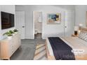 Serene bedroom with modern decor, including a sleek dresser and artwork, leading into an ensuite bathroom at 5407 Windy Valley Dr, Charlotte, NC 28208