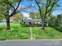 Lovely home with a well-maintained lawn and established trees, offering a serene setting and classic appeal at 5876 Wedgewood Dr, Charlotte, NC 28210
