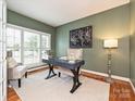 Bright office space featuring a large window, hardwood floors and a modern desk at 6144 Abergele Ln, Matthews, NC 28104