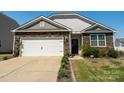 Charming home with stone accents, a well-manicured lawn, and a two-car garage at 6816 Pennyroyal Way, Charlotte, NC 28216