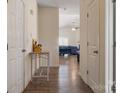 Hallway with hardwood floors leading to a living area with vaulted ceiling and a ceiling fan at 6816 Pennyroyal Way, Charlotte, NC 28216