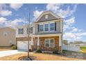 Inviting two-story home with stone facade, well-manicured landscaping, and a welcoming entrance at 715 Saddlebred Ln, Locust, NC 28097