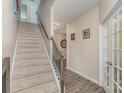Hallway with stairs, wood-look floors, neutral walls, and a white-framed glass door at 715 Saddlebred Ln, Locust, NC 28097