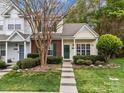 Charming townhome with brick and siding, green door and shutters, and landscaped front yard at 8230 Rudolph Rd, Charlotte, NC 28216
