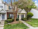 Charming townhome with brick and siding, green door and shutters, and landscaped front yard at 8230 Rudolph Rd, Charlotte, NC 28216