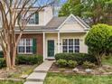 Charming townhome with brick and siding, green door and shutters, and landscaped front yard at 8230 Rudolph Rd, Charlotte, NC 28216